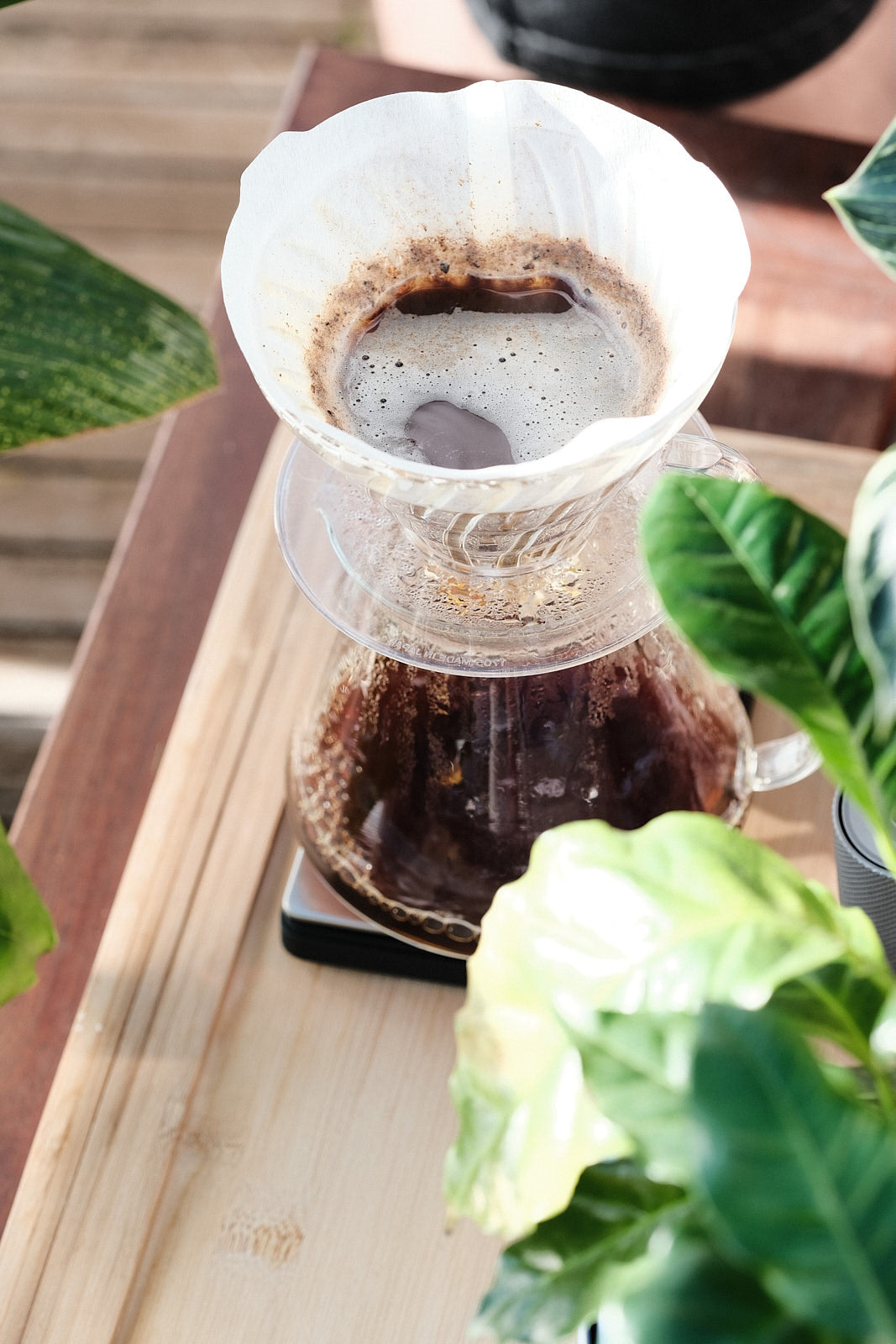 V60 Handfilter mit frisch aufgebrühtem Kaffee auf Holztablett