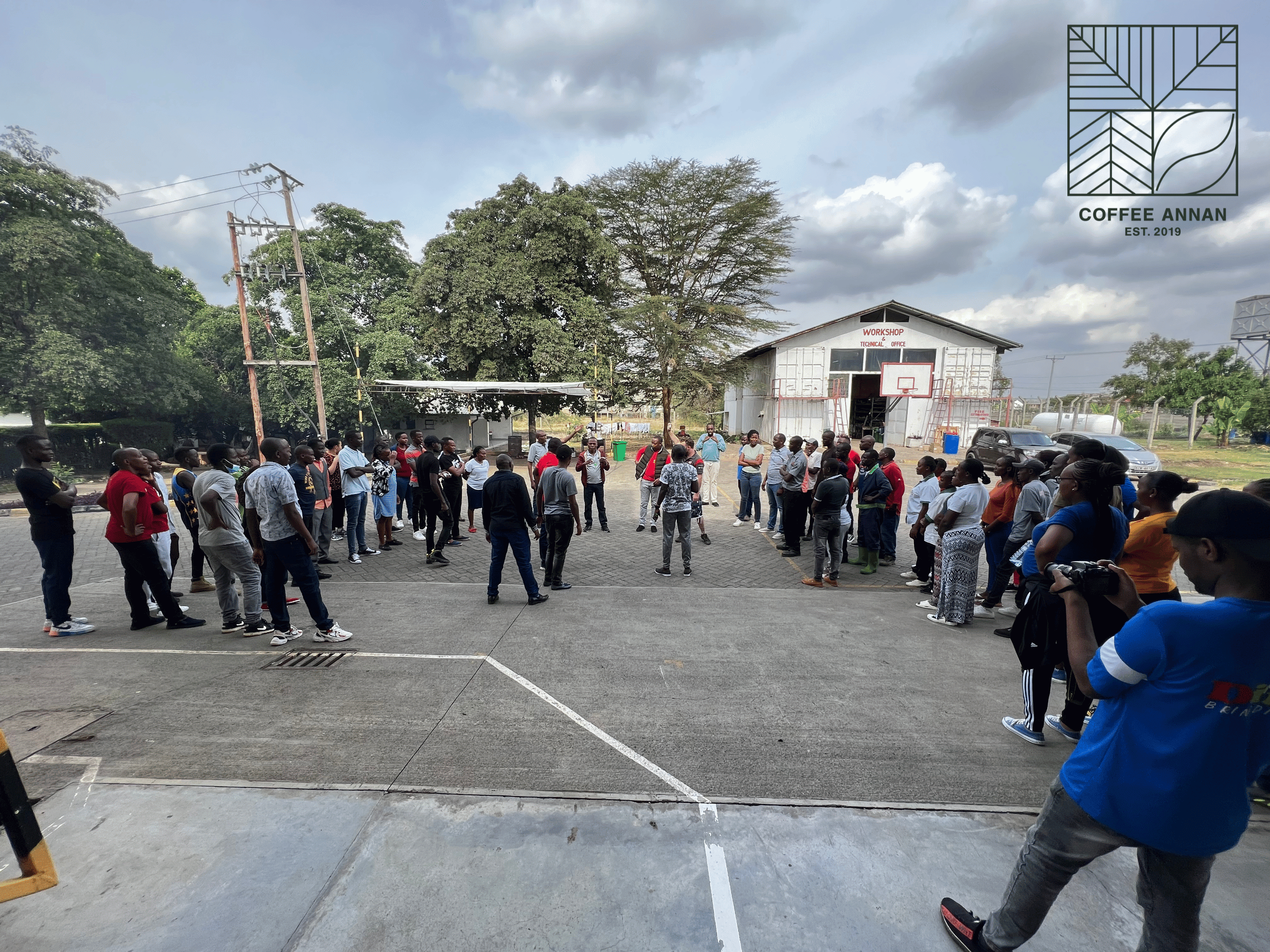 Menschen versammeln sich auf einem Platz vor einem Gebäude – Gruppenfoto bei einer inklusiven Veranstaltung